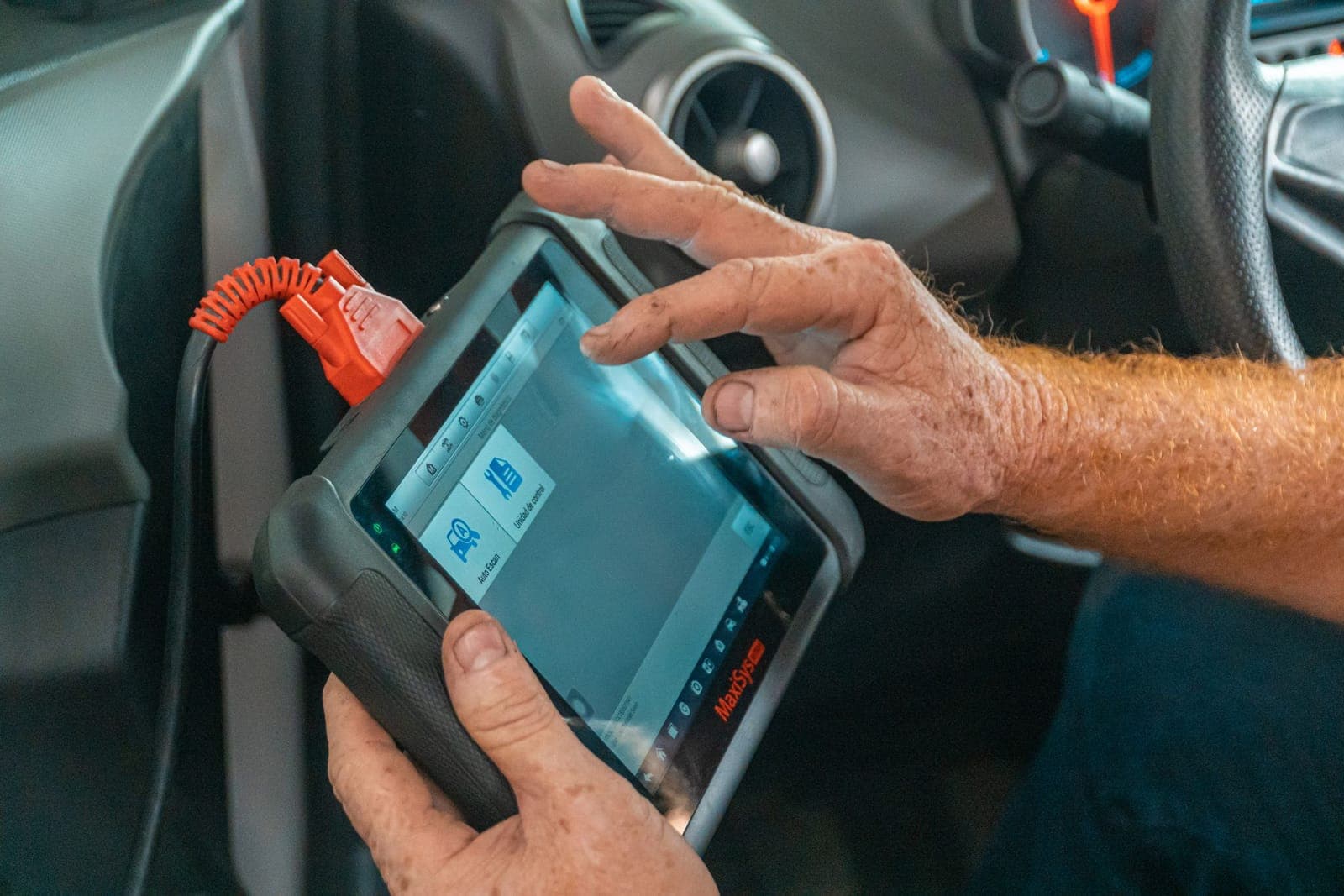 Tablette de diagnostic branchée sur la prise OBD, dans l'habitacle